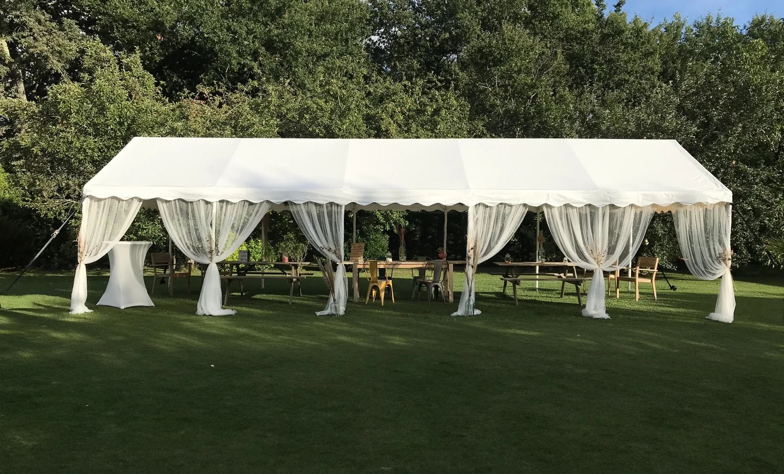 Chapiteau ouvert avec rideaux et mobilier