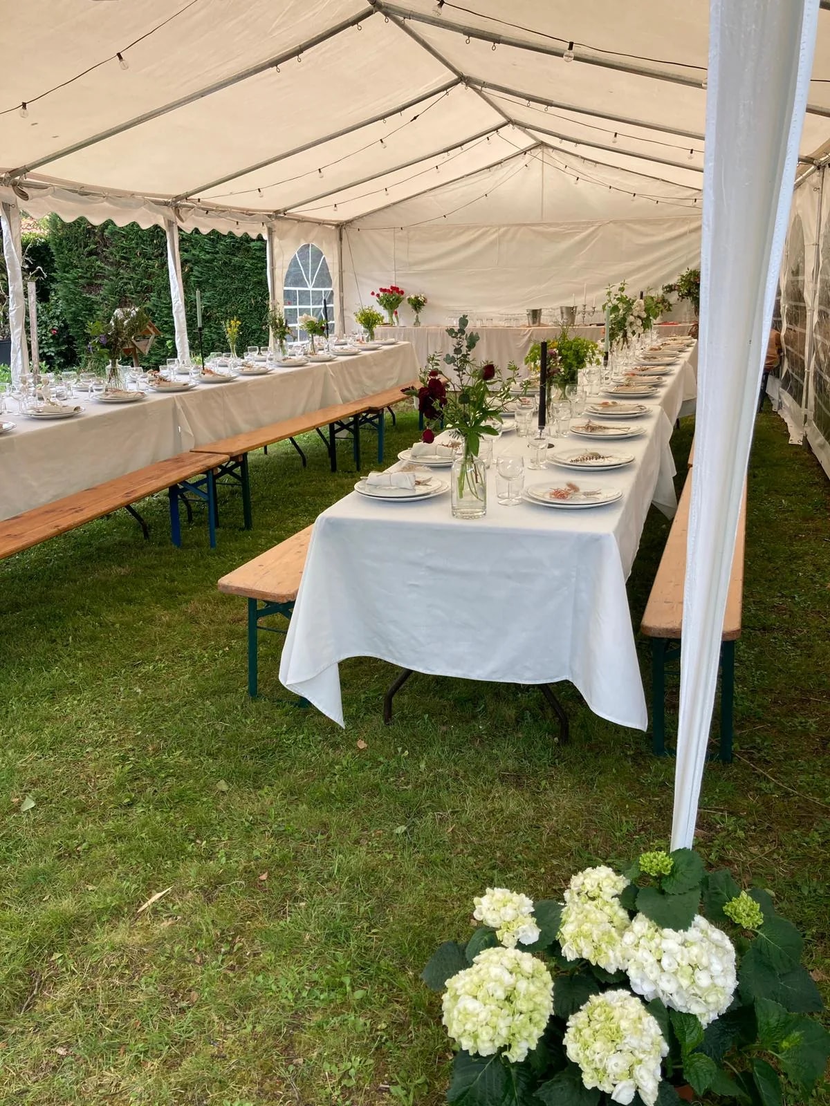 Table de réception dressée sous chapiteau avec décoration florale